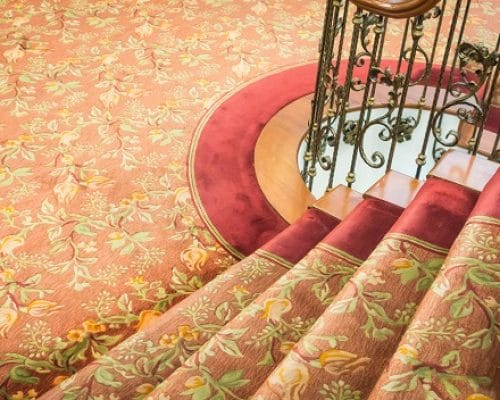 Close up of Staircase covered with carpet .